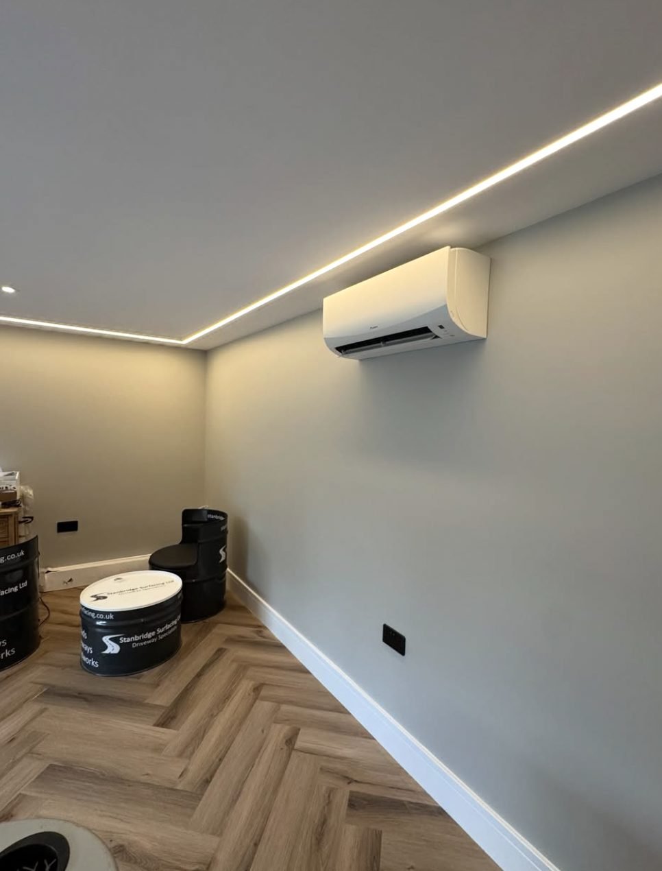 Wall-mounted indoor air conditioning unit installed in a garden room with feature ceiling lighting